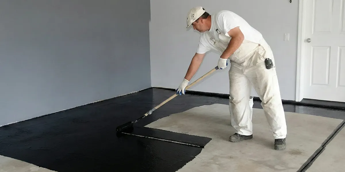 basement waterproofing professional applying waterproof coating to protect a basement floor in Clearwater, FL